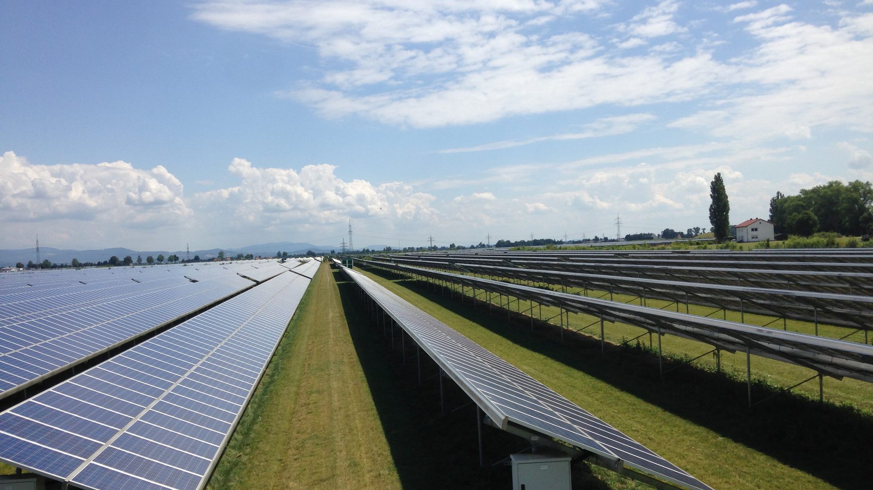 Modulreihen eines Solarparks unter bewölktem Himmel